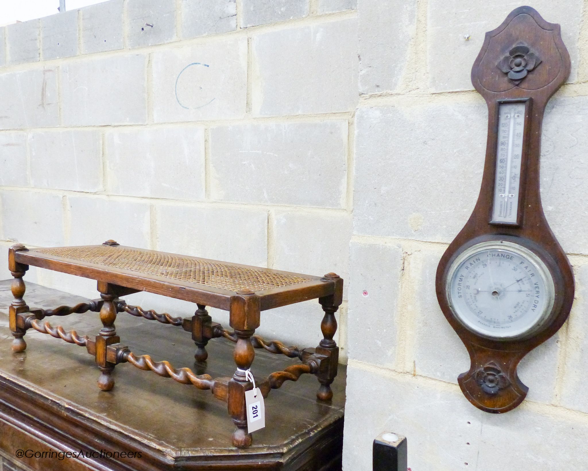 An oak footstool, width 76cm, depth 30cm, height 27cm and an aneroid barometer, length 58cm, width 19cm